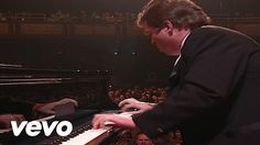 a man playing the piano in front of an audience