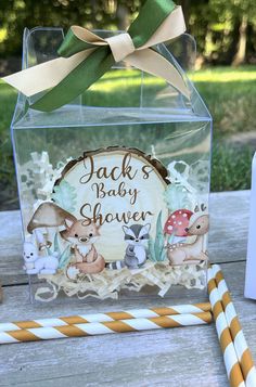 a baby shower box with deer and mushrooms on it, next to two straws