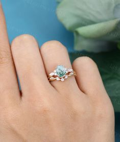 a woman's hand with a ring on it and a rose in the background