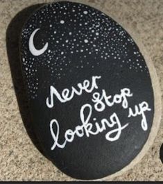 a rock with the words never stop looking up written on it