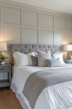 a bed with white sheets and pillows in a bedroom next to two lamps on either side of the bed