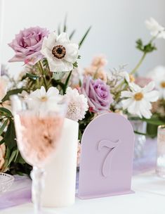 the table is set with flowers, candles and wine glasses for an elegant wedding reception