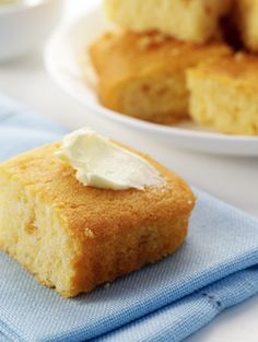 a piece of cake sitting on top of a blue towel next to a bowl of cream