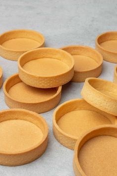 small pie pans sitting on top of a table next to each other in rows