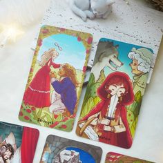 four tarot cards with pictures of people and animals on them sitting on a table