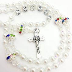 Elegant and personalised Rosary beads made with white pearl beads and silver round beads with multicoloured crystal for Our Father. This would be ideal as a gift for a goddaughter on her baptism. Suitable for many other occasions such as a christening, first holy communion, baptism, confirmation and much more! Add a name and/or Saint pendant to personalise and choose your own centrepiece with a wide variety available. Please select the colour of the Hail Mary beads from drop down menu then choos Customizable White Jewelry For Baptism, White Pearl Jewelry For Birthday, White 8mm Beads Jewelry For Baptism, White Rosary With Round Beads For Confirmation, White Pearl Rosary As A Gift, White Pearl Rosary As Gift, Beaded Rosary For Baptism, Spiritual Pearl Rosary For First Communion, Personalized White Rosary For Confirmation