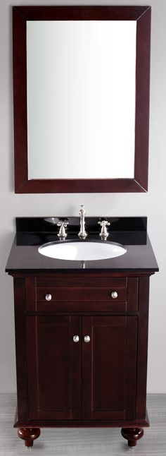 a bathroom vanity with a mirror above it and two faucets on the sink