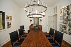 a dining room table with black chairs and a chandelier hanging from the ceiling