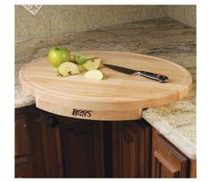 a wooden cutting board sitting on top of a kitchen counter