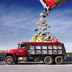 a red truck filled with donuts flying out of it's back