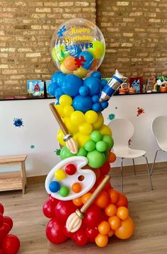 a bunch of balloons are stacked on top of each other in the shape of a tower