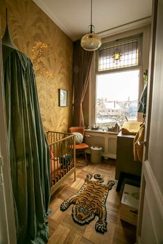 a baby's room with a tiger rug on the floor next to a crib