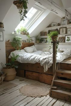 an attic bedroom with white walls and wooden floors, lots of plants on the bed