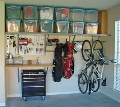 a garage with several storage bins on the wall and two bikes parked in front of it