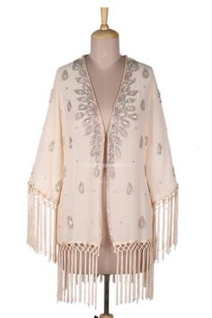 When you reach for this jacket you'll know it's going to be a special night out. Presented by Vijay Singh in India the open jacket is crafted from polyester crepe in the palest of apricot shades--think ivory with a bit more warmth. Artisans lavish the jacket with silvery glass beads and iridescent sequins that play with the light. Long silky fringe lends bohemian chic to the cuffs and hem. Summer Evening Long Sleeve Cardigan, Beaded Fringe Long Sleeve Outerwear For Spring, Long Sleeve Outerwear With Beaded Fringe For Spring, Winter Outerwear With Beaded Fringe And Long Sleeves, Long Sleeve Summer Evening Outerwear, Summer Evening Long Sleeve Outerwear, Spring Bohemian Outerwear With Sequins, Embellished Long Sleeve Summer Outerwear, Summer Long Sleeve Embellished Outerwear