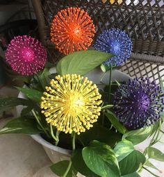 some colorful flowers are in a white bowl