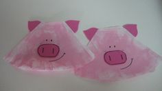 two pink pig shaped paper plates sitting on top of a white table next to each other