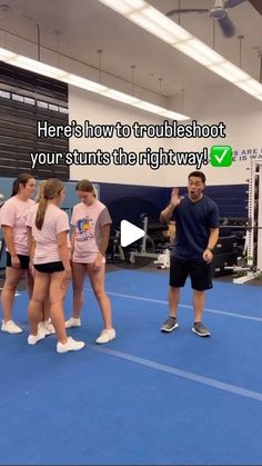 a group of young people standing on top of a blue floor next to each other