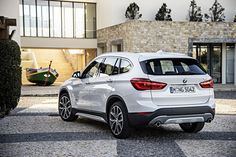 a white bmw suv parked in front of a building