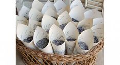 a wicker basket filled with lots of paper cones covered in blue and white ink