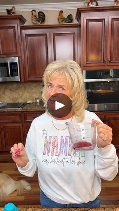 a woman holding a blender in her hand and making a drink out of it