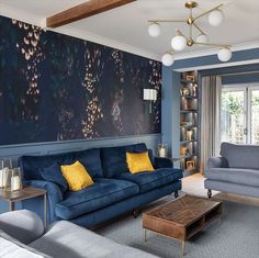 a living room with blue couches and yellow pillows on the walls, along with a coffee table