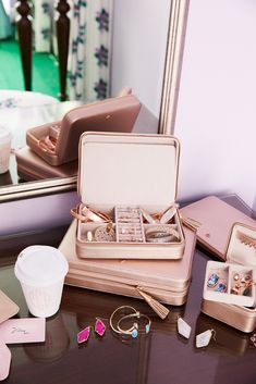 an open suitcase sitting on top of a table next to a mirror and jewelry box