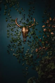 a bull's head mounted to the side of a wall covered in ivy