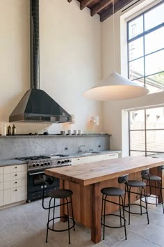 a kitchen with an island, stove and oven in the middle of it's room