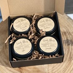 four candles in a box sitting on top of a wooden table