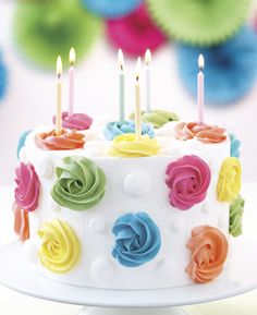 a birthday cake with colorful icing and lit candles on it that says do you love cake?