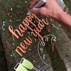 someone is writing happy new year on the ground with scissors and paper machs in front of them