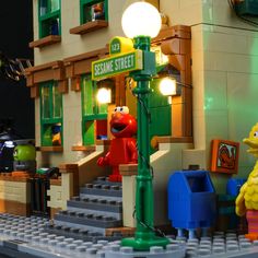 the sesame street sign is displayed in front of a lego building with some characters around it