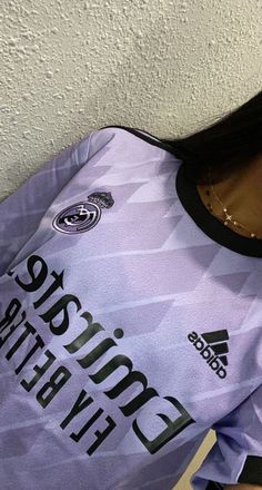 a close up of a soccer jersey with the name adidas on it and an image of a woman's face