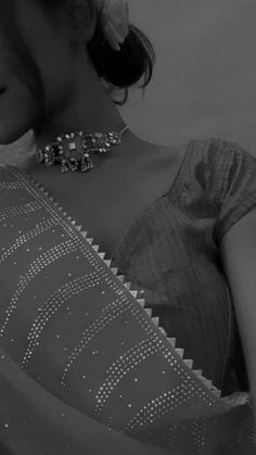 black and white photograph of a woman wearing a dress with beaded details on it