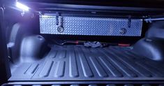 the back end of a pickup truck with its cargo compartment open and lights turned on