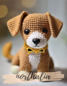 a crocheted dog with a yellow bow tie sitting on the ground next to a sign that says northalila