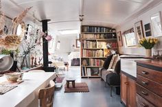 a living room filled with furniture and bookshelves next to a dining room table