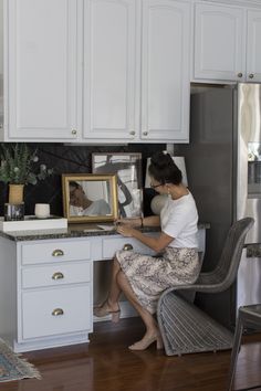 a woman sitting at a kitchen counter with a framed photo