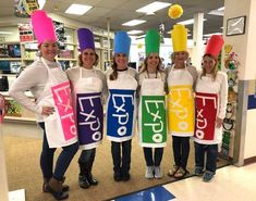 four women wearing funny hats and aprons in a store