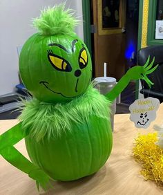 a large green pumpkin sitting on top of a wooden table