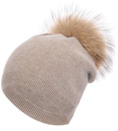 a beige hat with a brown fur pom