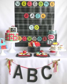 a table topped with lots of cakes and cupcakes