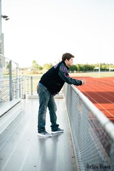 a man leaning against a fence on top of a tennis court