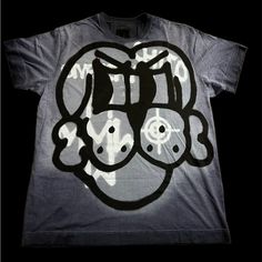 a t - shirt that has been spray painted with black and white graffiti on it