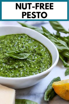 a white bowl filled with pesto next to an orange slice