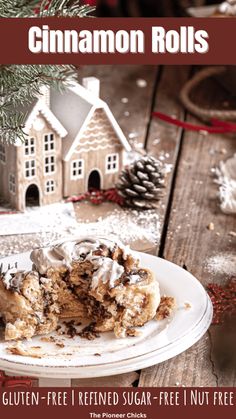 a white plate topped with cake next to a christmas tree and a small house in the background