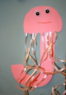 a pink paper cut out of a jellyfish with streamers around it's legs