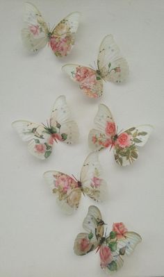 six white butterflies with pink flowers on them