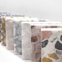 marbled papers lined up in rows on a white surface with different colors and shapes